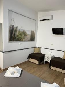 a room with two beds and a painting on the wall at B&B Med - Finestra sul Mare in Contrada Mastrissa