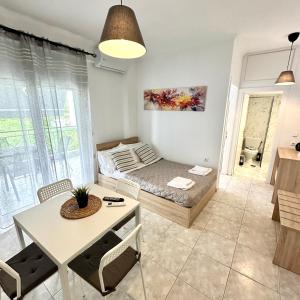 a living room with a bed and a table at R&T Apartments in Kallithea Halkidikis