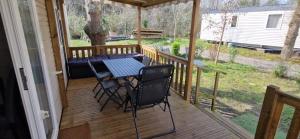 a screened porch with a table and chairs on it at Cosy mobil home 3Ch en forêt, parking inclus, plage à 15mn à pied in Capbreton