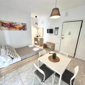 a living room with a bed and a table and chairs at R&T Apartments in Kallithea Halkidikis