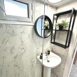 a bathroom with a sink and a mirror at R&T Apartments in Kallithea Halkidikis