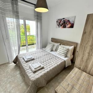 a bedroom with a bed with pillows and a window at R&T Apartments in Kallithea Halkidikis