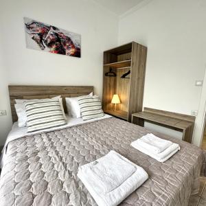 a bedroom with a bed with two towels on it at R&T Apartments in Kallithea Halkidikis