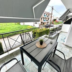 a table and chairs on a balcony with a view at R&T Apartments in Kallithea Halkidikis