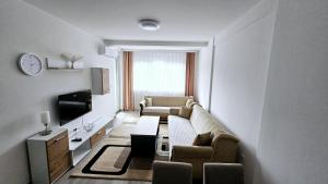 a living room with a couch and a tv at Apartman Car in Novi Pazar