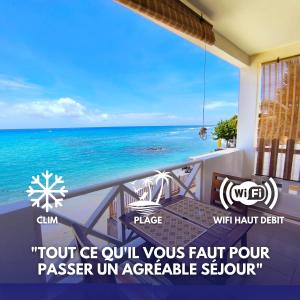 a view of the ocean from a balcony at Le Caro - Studio pieds dans l'eau in Saint-Gilles les Bains