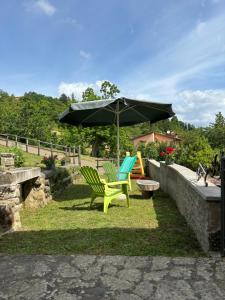 a couple of chairs and an umbrella and a table at Voce del Casentino in Castel San Niccolò