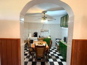 a dining room with a table and a kitchen at Pensiunea Nóra's Garden in Brîncoveneşti +5 photos