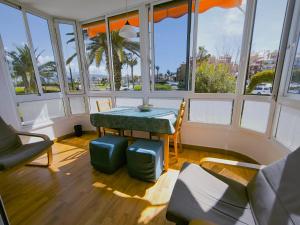 a room with a table and chairs and windows at Cayo Beach in Torrox Costa