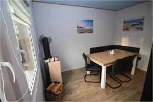 a dining room with a table and chairs in a room at Ferienwohnung ANKERPLATZ mit KAMIN direkt am STRAND in Altenkirchen