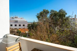 a balcony with a wooden bench and a building at Gyula Old Town Apartment in Albufeira