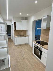 a kitchen with white cabinets and a stove top oven at Deluxe Apartment a 2 passi dal mare - FIERA GENOVA in Genova