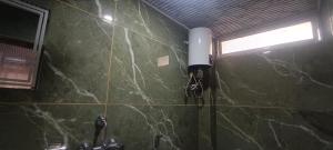 a bathroom with a green marble wall with a sink at Hillcrest Prapti Homestay in Darjeeling