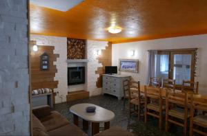 un salon avec un canapé, une table et des chaises dans l'établissement Le petit sport, à La Salle Les Alpes