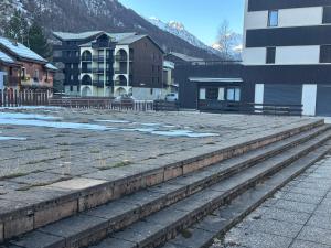 un groupe d'escaliers dans une ville avec des bâtiments dans l'établissement Le petit sport, à La Salle Les Alpes