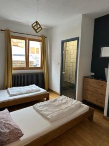 une chambre avec deux lits et une fenêtre et un miroir dans l'établissement Le petit sport, à La Salle Les Alpes