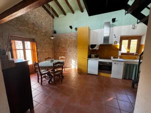 a kitchen with a table and a dining room at Cal Capdevila Apartaments in Pira