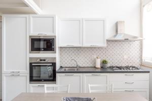 uma cozinha branca com armários brancos e um lavatório em Calefati Guest House- Apulia Guest House em Bari mais 17 fotografias