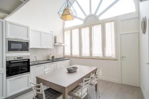 uma cozinha com uma mesa com cadeiras e uma janela em Calefati Guest House- Apulia Guest House em Bari