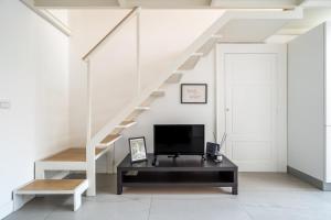uma sala de estar com uma televisão e uma escada em Calefati Guest House- Apulia Guest House em Bari