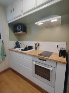 a kitchen with white cabinets and a stove top oven at Gîte Belle vue au Gros Caillou, 13mn du Zoo de Beauval in Saint-Romain-sur-Cher