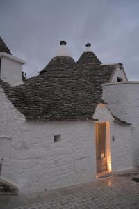 a white building with a roof with a wooden door at tulipano CASA VACANZE SUITE CURCUMA in Alberobello