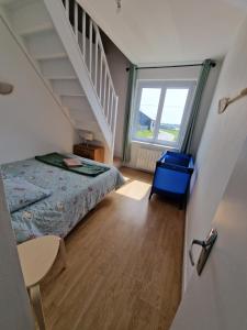 a small bedroom with a bed and a staircase at Maison de ville à saint coulomb in Saint-Coulomb
