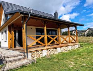 a house with a large porch with wooden doors at Przystanek Przylasek in Grywałd