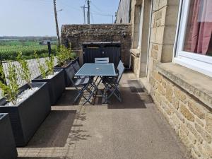 a patio with a blue table and some plants at Maison de ville à saint coulomb in Saint-Coulomb