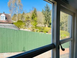 a window with a view of a green fence at Victoria Cottage, Ironbridge in Ironbridge