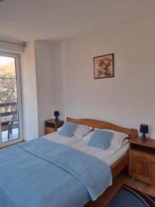 a bedroom with a bed with a blue blanket at Pensiunea Pitic in Cheia