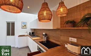 a kitchen with pendant lights and white cabinets at Les Inattendus - Cottages Premium, Proche Mer avec Parking privé in Boulogne-sur-Mer