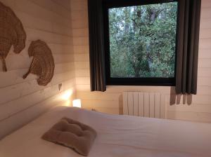 a bedroom with a white bed with a window at Eco-lodges Lacanau Moutchic Inn - 4 pers in Lacanau