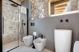 a bathroom with a toilet and a glass shower at Casa Limonaia al Pos in Tignale +21 photos