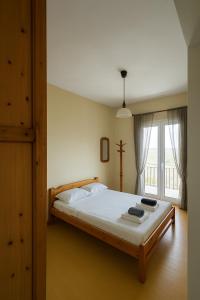 a bedroom with a large white bed with a window at Θέα Αιγαίου in Karavostamo