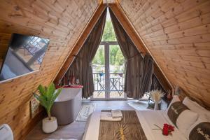 a room with a large window and a tub in a attic at Bujtina Miqesia in Theth