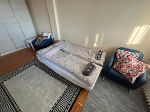 a room with a bed and a chair and a rug at Comfort & Style Panoramic Urban Retreat 2 in Belgrade