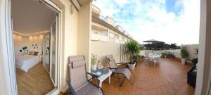 an apartment balcony with chairs and a bed and tables at Brisa Marina in Mogro