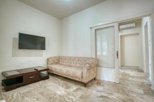 a living room with a couch and a tv at Millarakia House in Chios