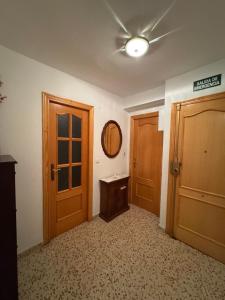 an empty room with two wooden doors and a mirror at La Turia Soleada in Cullera