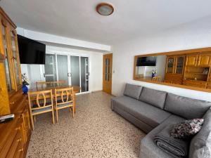 a living room with a couch and a dining room at La Turia Soleada in Cullera