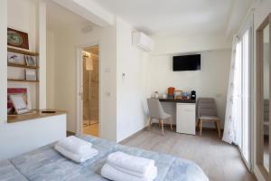 a white bedroom with a bed and a kitchen at Locus Amoenus in Riomaggiore