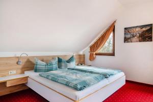 a bedroom with a bed with blue pillows and a window at Haus Annette in Immenstaad am Bodensee