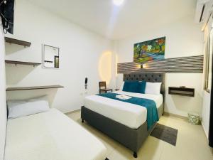 a hotel room with two beds and a bed and a desk at ANAJIRAWAA HOTEL in Ríohacha