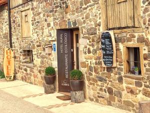 kamienny budynek z drzwiami z napisem w obiekcie Hotel Rural Las Encinas w mieście Santa María de Redondo