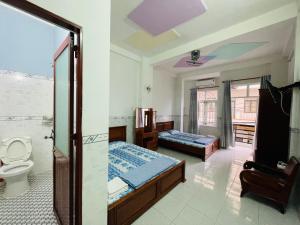 une salle de bain avec deux lits et des toilettes dans une chambre dans l'établissement Nhà Nghỉ Hải Đăng, à Quy Nhơn