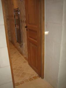 a bathroom with a wooden door and a tile hallway at Villa - La chambre des Dames in Vallères