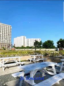 a group of picnic tables with buildings in the background at JL Condotel - Near Airport - Oceanview in Lapu Lapu City +13 photos