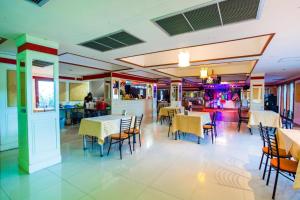 a dining room with tables and chairs in a restaurant at Good View Residence in Lampang