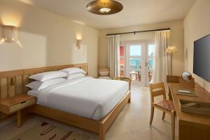 a bedroom with a bed and a desk and a television at Sheraton Miramar Resort El Gouna in Hurghada